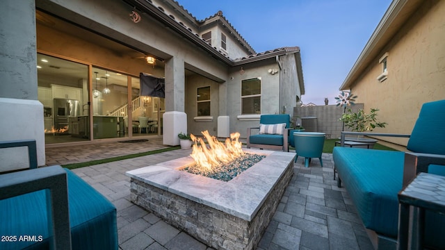 patio terrace at dusk featuring an outdoor living space with a fire pit