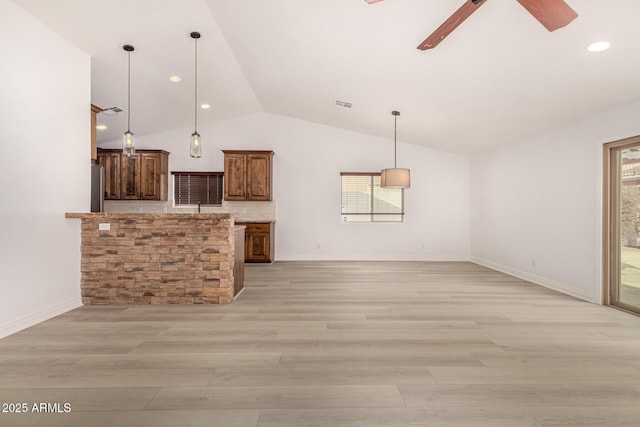 kitchen featuring decorative light fixtures, light wood-type flooring, and tasteful backsplash