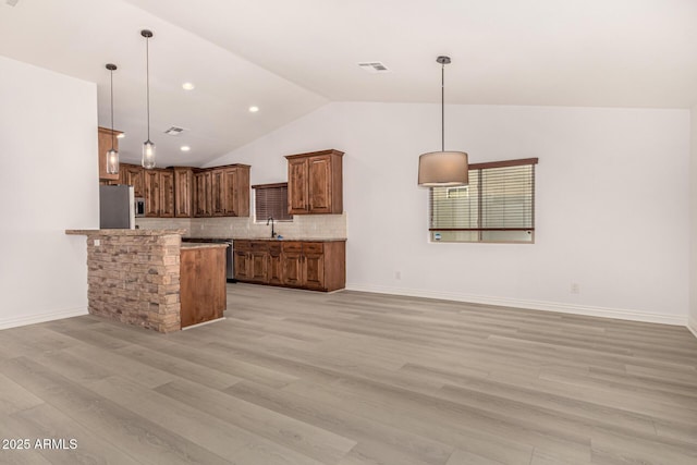 kitchen with backsplash, stainless steel appliances, hanging light fixtures, and sink