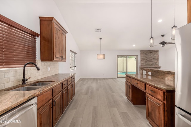 kitchen featuring ceiling fan, sink, hanging light fixtures, stainless steel appliances, and decorative backsplash