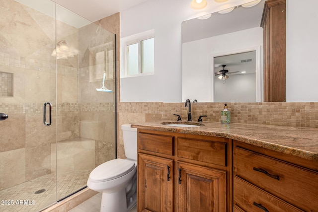 bathroom featuring ceiling fan, an enclosed shower, toilet, vanity, and tile walls