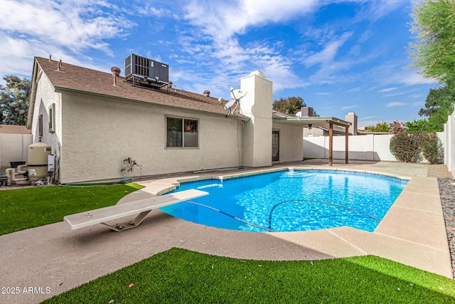 view of pool featuring central air condition unit, a patio area, a diving board, and a lawn