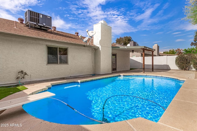 view of pool with central AC unit, a diving board, a patio area, and ceiling fan