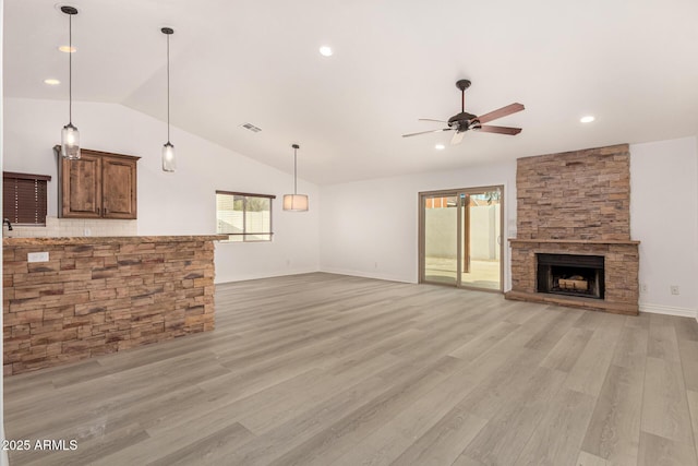 unfurnished living room featuring a fireplace, light hardwood / wood-style floors, ceiling fan, and lofted ceiling