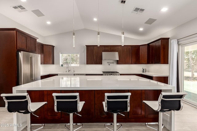 1513 S 108th Way, Chandler, AZ 85286 - kitchen featuring high end fridge, under cabinet range hood, vaulted ceiling, stove, and light countertops