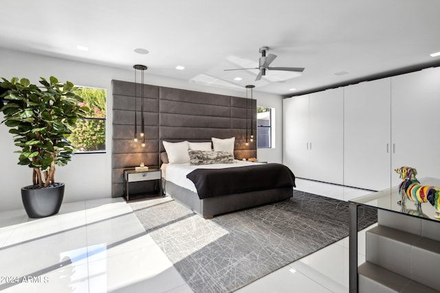 bedroom featuring ceiling fan, light tile patterned floors, and multiple windows