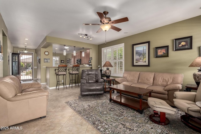 living area featuring ceiling fan, baseboards, and light tile patterned flooring