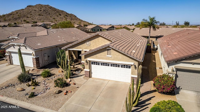 view of front facade featuring stucco siding, an attached garage, driveway, and a tiled roof