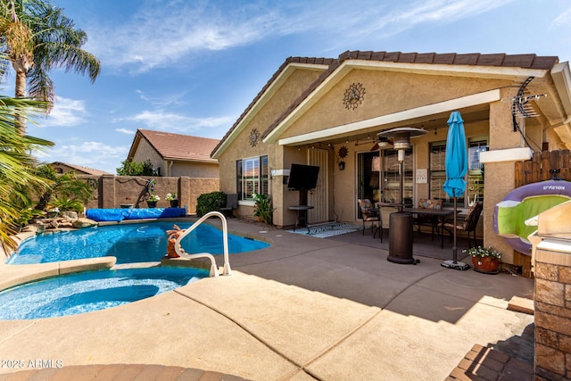 view of swimming pool featuring a ceiling fan, fence, a fenced in pool, an in ground hot tub, and a patio area