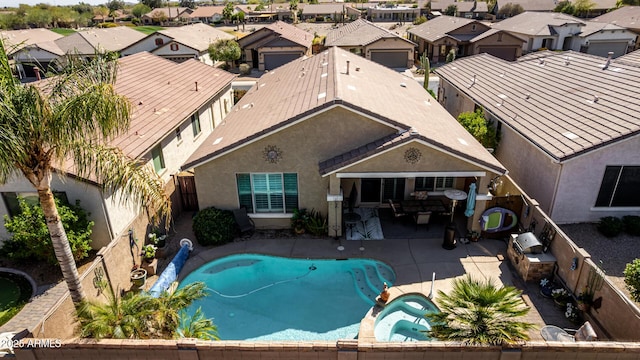 view of swimming pool featuring a patio area, a fenced backyard, a residential view, and a pool with connected hot tub