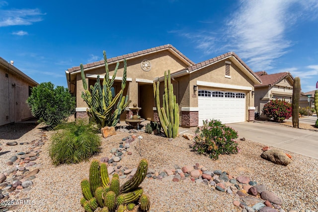 view of front of home with brick siding, a tiled roof, concrete driveway, stucco siding, and a garage