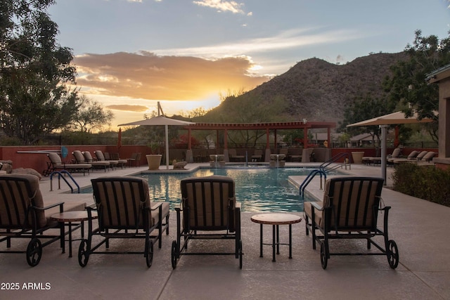 community pool featuring a patio, fence, an outdoor living space, a pergola, and a mountain view