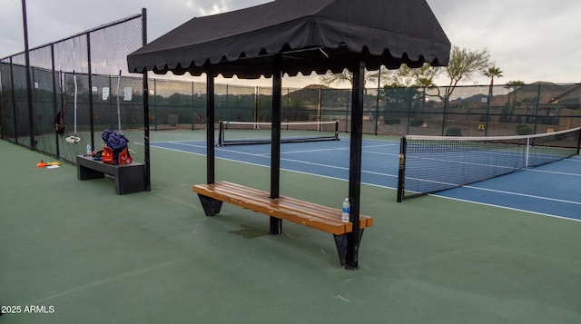 view of tennis court featuring fence