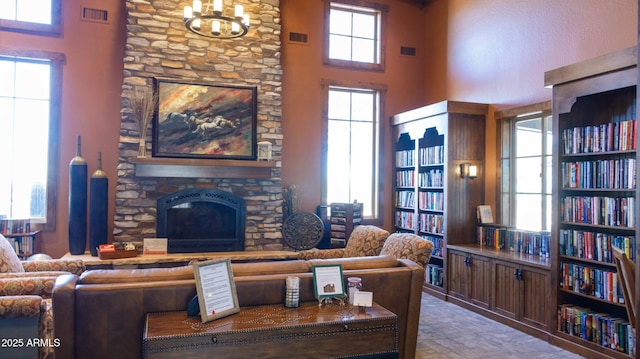 living room featuring visible vents, a fireplace, and a high ceiling