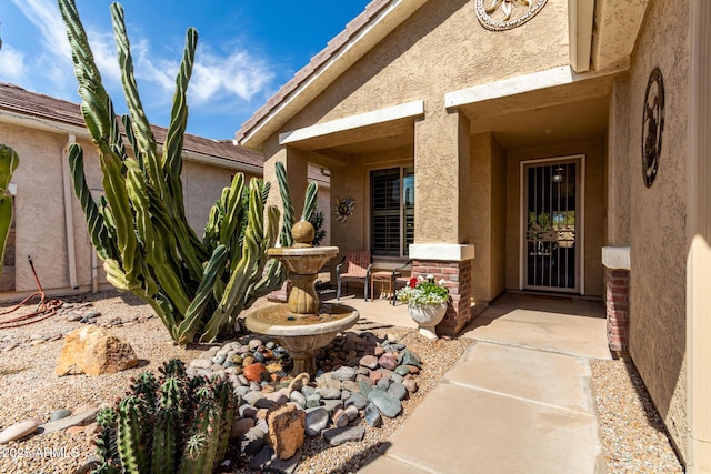 doorway to property featuring stucco siding