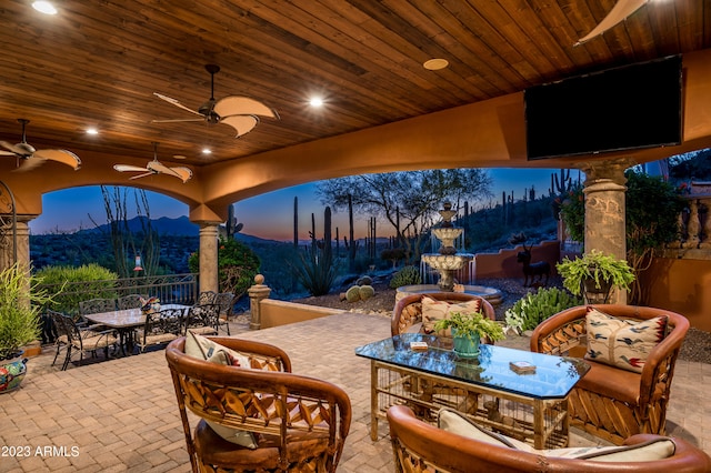 patio terrace at dusk with a mountain view and ceiling fan