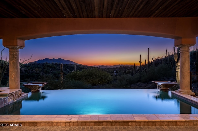 pool at dusk with a mountain view