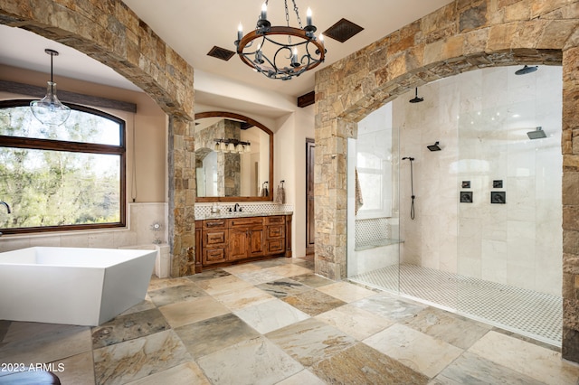 bathroom featuring an inviting chandelier, plus walk in shower, vanity, tile walls, and tile floors