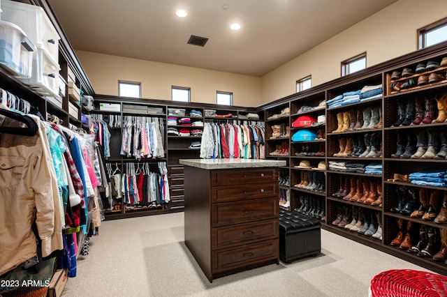 walk in closet featuring light colored carpet