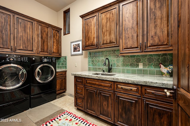 laundry area with light tile floors, cabinets, sink, and washer and clothes dryer