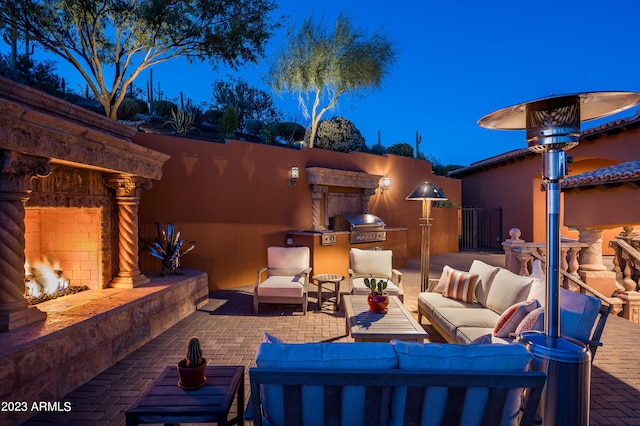 view of patio with area for grilling, an outdoor living space with a fireplace, and a grill