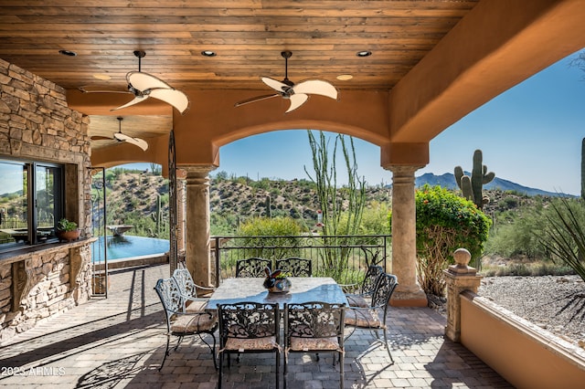 view of patio featuring ceiling fan and a mountain view