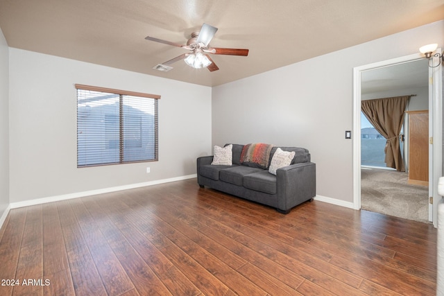 living room featuring ceiling fan and dark hardwood / wood-style flooring