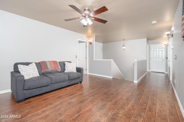 living room featuring ceiling fan and dark wood-type flooring