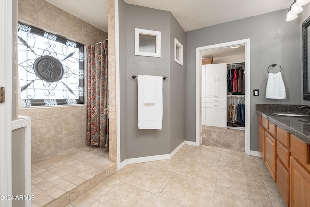 bathroom with tile patterned floors, vanity, and curtained shower