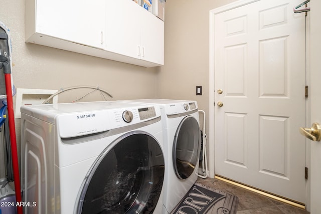 clothes washing area featuring cabinets and washer and clothes dryer