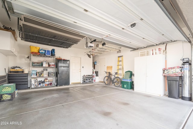 garage featuring black fridge and a garage door opener