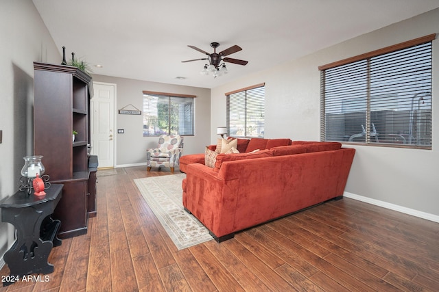 living room featuring ceiling fan and dark hardwood / wood-style flooring