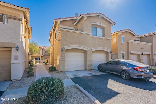 multi unit property featuring a garage, a tile roof, driveway, and stucco siding