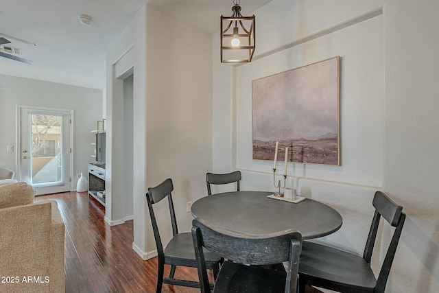 dining room with baseboards, visible vents, and dark wood-style flooring