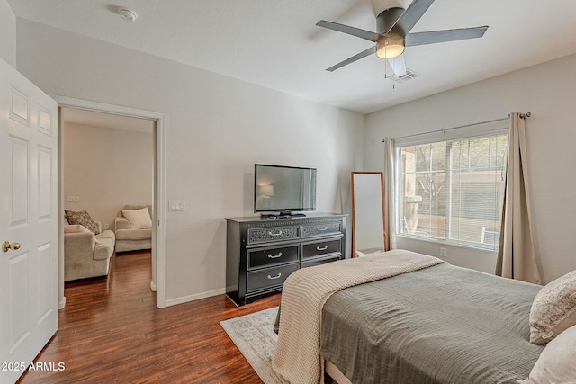 bedroom featuring ceiling fan, dark wood-type flooring, visible vents, and baseboards