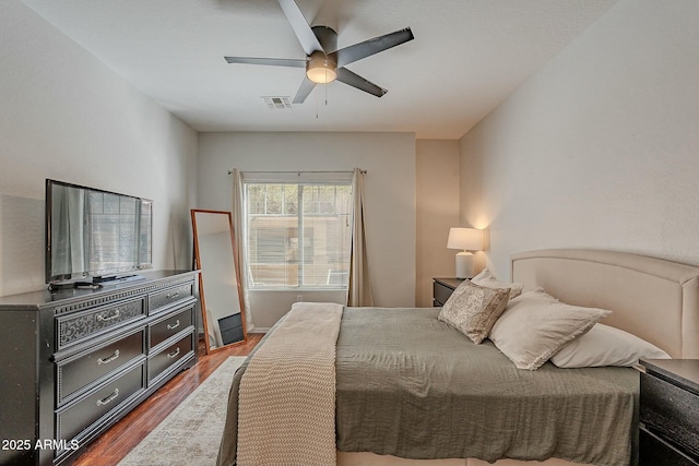 bedroom featuring a ceiling fan, visible vents, and dark wood-type flooring