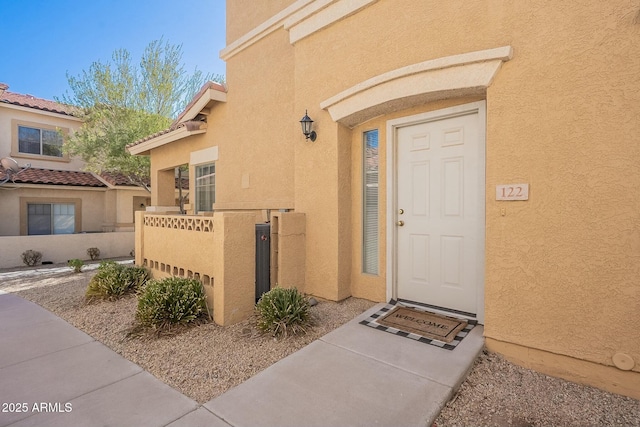 doorway to property featuring stucco siding