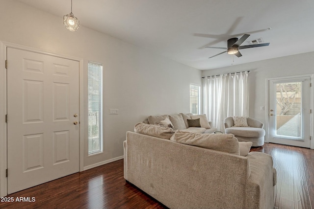 living area featuring baseboards, dark wood-style flooring, visible vents, and a ceiling fan