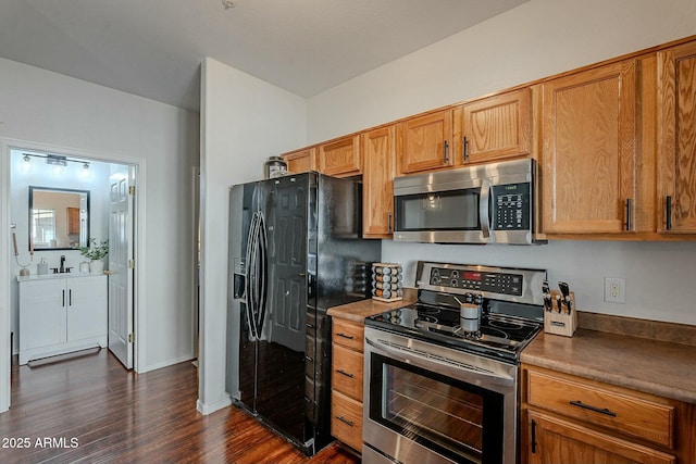 kitchen featuring stainless steel appliances, dark wood-style flooring, and brown cabinets