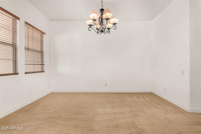 carpeted empty room featuring a notable chandelier