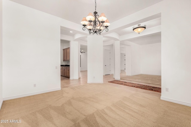 carpeted spare room featuring a notable chandelier