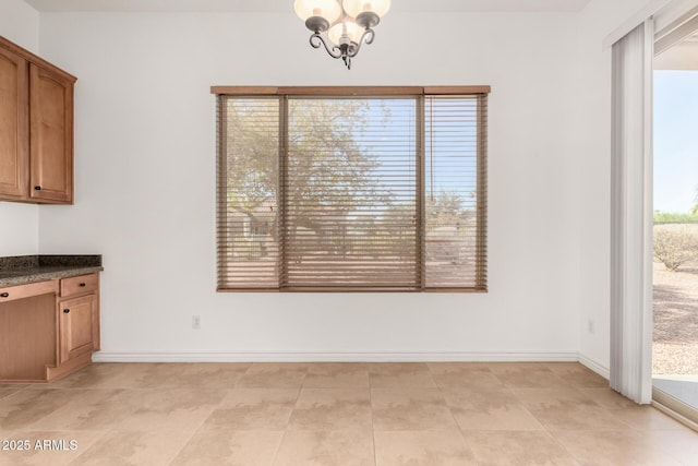 unfurnished dining area with a notable chandelier