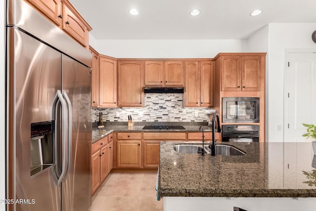 kitchen with dark stone countertops, sink, decorative backsplash, and black appliances