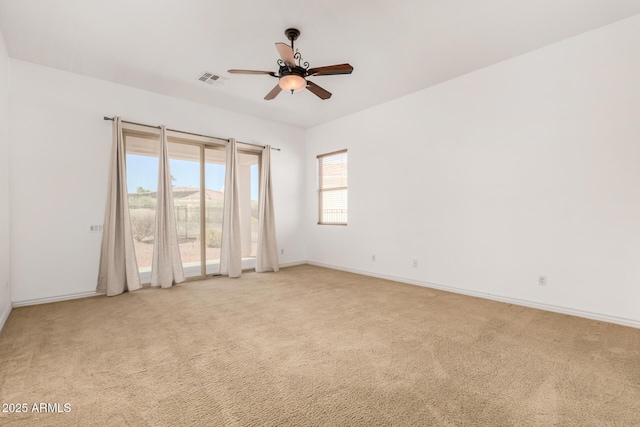 spare room featuring light carpet and ceiling fan