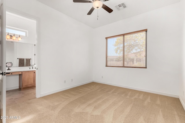 carpeted empty room with sink, a wealth of natural light, and ceiling fan