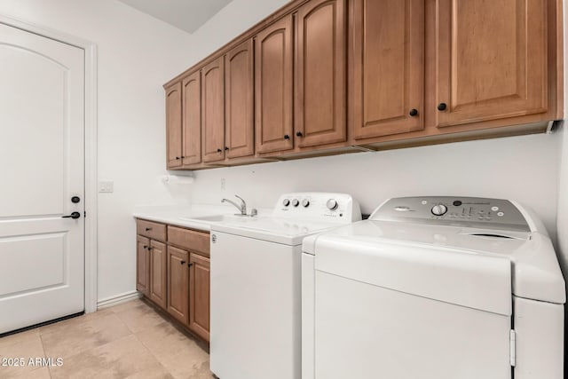 laundry area featuring cabinets, sink, light tile patterned floors, and washing machine and clothes dryer