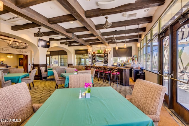 dining room featuring indoor bar, coffered ceiling, and beam ceiling