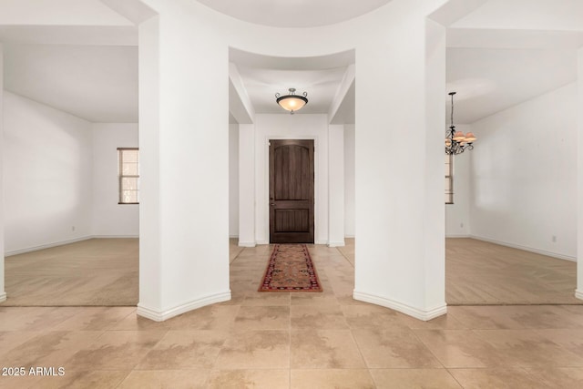 tiled foyer featuring a chandelier