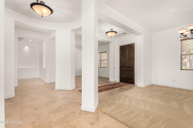 entryway with light carpet and a notable chandelier