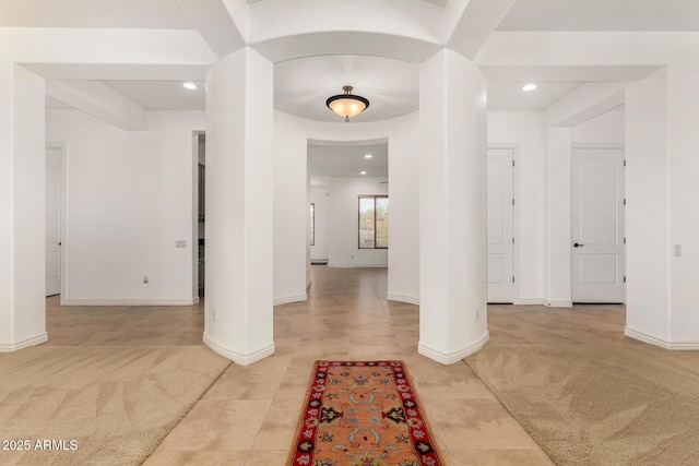 foyer entrance with decorative columns and carpet floors